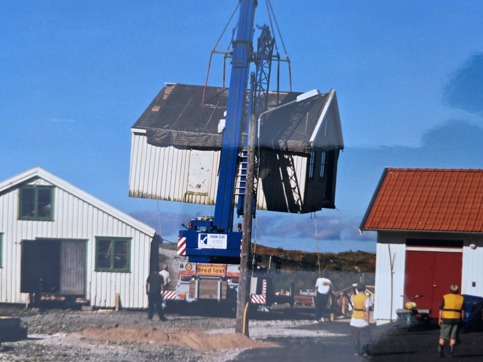 Två husdelar svävar i luften vid montering